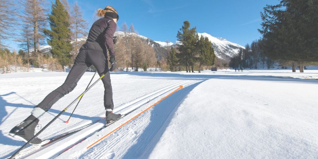 A beginner skier practicing walking with skis on flat terrain.